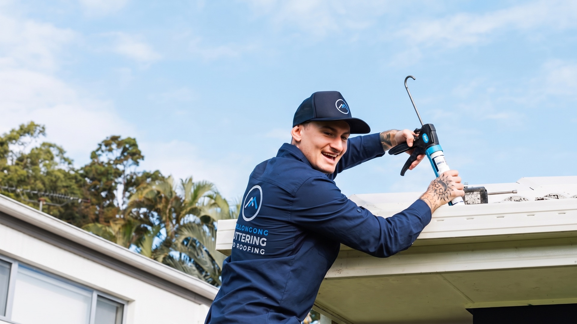 Roofer sealing a gutter line on a suburban home